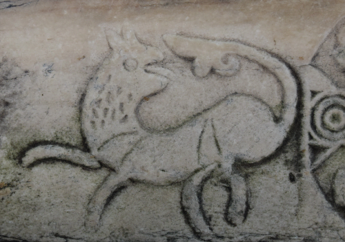 ancient stone carving of dog chasing his tail