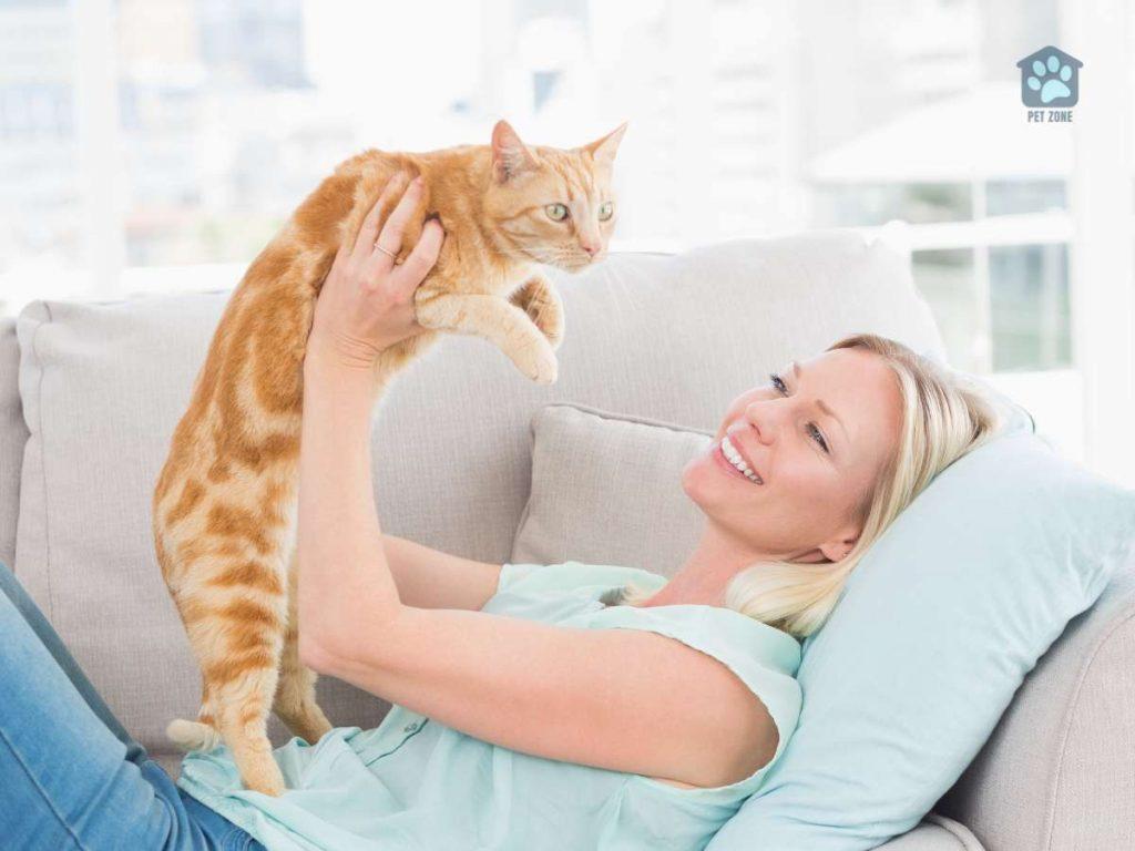 woman holding up her cat