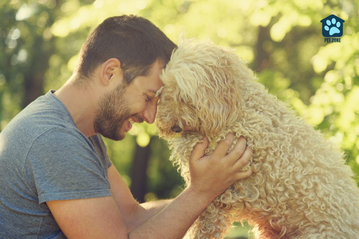 man touching foreheads with his dog