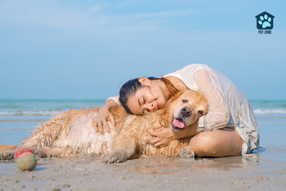 woman hugging her dog at the beach
